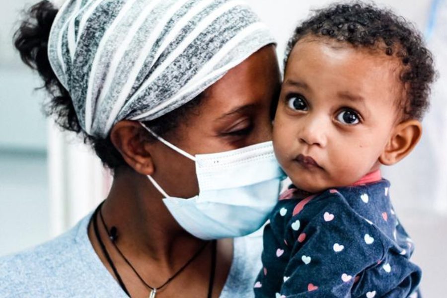A mother holds her child after treatment